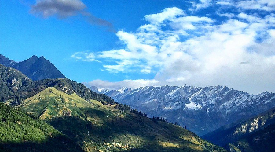 Green Manali valley under snow peaks